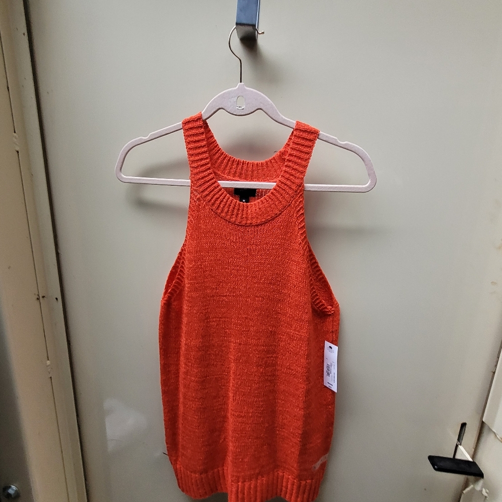 Sleevless knitted bright orange sweater.